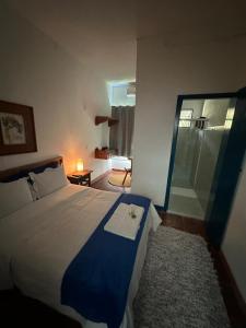 a bedroom with a bed and a glass shower at Pousada Toro Real in Tiradentes