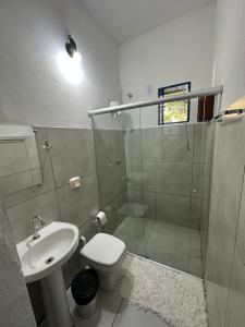 een badkamer met een douche, een toilet en een wastafel bij Pousada Toro Real in Tiradentes