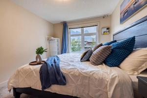 a bedroom with a bed with pillows and a window at Lux 2BR/3BD Suite/Mountain View! in Canmore