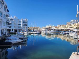 een groep boten aangemeerd in een jachthaven met gebouwen bij Edificio Europark in Benalmádena