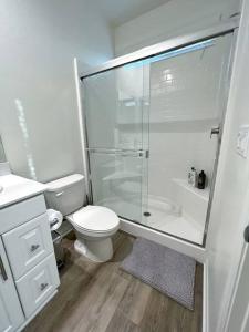 een witte badkamer met een douche en een toilet bij Modern Lux Home Near Disneyland And In The Heart Of OC! in Santa Ana