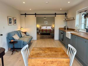 a kitchen and living room with a couch and a table at Cobblers Lodge in Lyme Regis