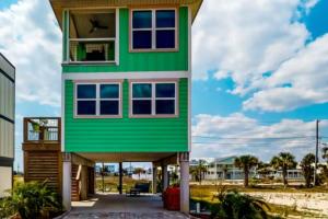 a house with a green exterior at Cornerstone Beachside Cottage in Mexico Beach