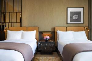 2 Betten in einem Hotelzimmer mit weißen Kissen in der Unterkunft The Ritz-Carlton New York, NoMad in New York
