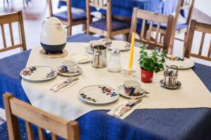 einen Tisch mit Tellern und Küchenutensilien auf einem blauen Tischtuch in der Unterkunft Landgasthof Sepplwirt in Kindberg