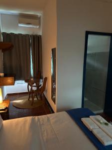 a bedroom with a bed and a table and a mirror at Pousada Toro Real in Tiradentes