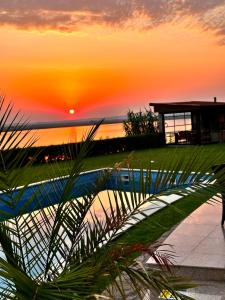 a sunset over a swimming pool in a resort at Casa Miralago Boutique in Tulcea