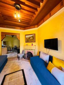 sala de estar con sofá azul y chimenea en Palmeraie 3 Vue Piscine et Jardin, en Marrakech