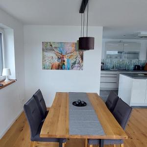 - une salle à manger avec une table et des chaises en bois dans l'établissement AmSee50, à Neuental