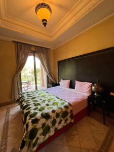 a bedroom with a large bed with a large window at Palmeraie 3 Vue Piscine et Jardin in Marrakech
