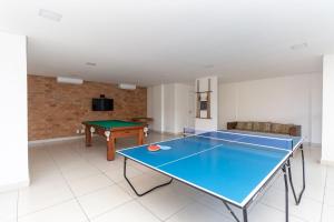 mesa de ping pong en la sala de estar con una pelota de ping pong en Temporada do seu jeito - Apes na Enseada, en Guarujá