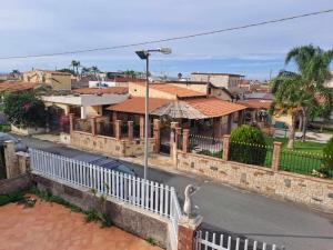 a city street with a white fence and houses at Casa Melina e enzo in Agnone Bagni