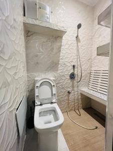 a bathroom with a toilet with a shower in it at Palmeraie 3 Vue Piscine et Jardin in Marrakech