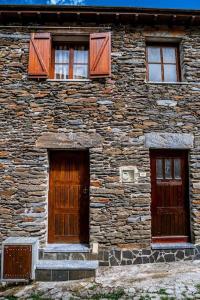 un edificio de piedra con 2 puertas y ventanas en Casa da Ernesta, en Mondim de Basto