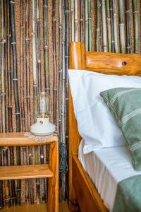 - une chambre dotée d'un lit en bois avec une bougie sur le mur dans l'établissement Casa da Ernesta, à Mondim de Basto