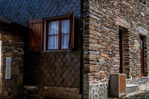 un edificio de ladrillo con puerta y ventana en Casa da Ernesta, en Mondim de Basto