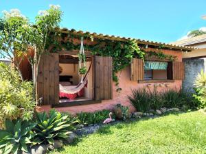 a house with a hammock in a garden at Loft romântico pé na areia in Itapoa