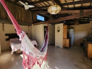 a hammock in a room in a house at Loft romântico pé na areia in Itapoa