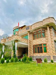 a stone building with a chair in front of it at Royal Guest House in Skardu