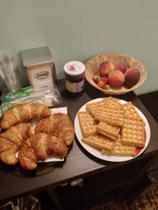 a table with two plates of bread and waffles and baskets of fruit at FLORIDA B&B Cingoli in Cingoli +16 photos