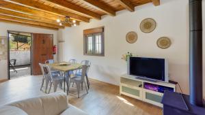a living room with a table and a tv at La Pasadilla Alozaina by Ruralidays in Alozaina