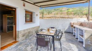 a table and chairs on the patio of a house at La Pasadilla Alozaina by Ruralidays in Alozaina
