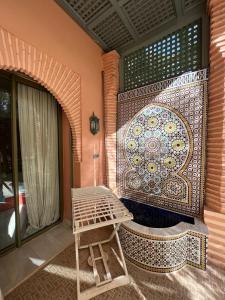 a patio with a mosaic wall and a bench at Palmeraie 3 Vue Piscine et Jardin in Marrakech