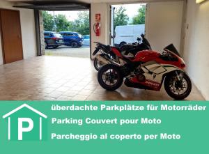 una motocicleta roja estacionada en un garaje en Hotel Montegrino, en Montegrino Valtravaglia