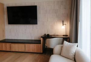 uma sala de estar com uma televisão, uma cadeira e uma secretária em Colima 71 Art - Community - Hotel em Cidade do México
