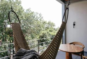 two hammocks hanging from a balcony with a table at Colima 71 Art - Community - Hotel in Mexico City