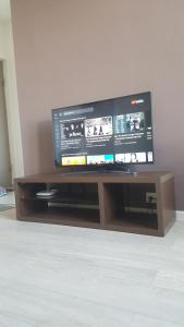 telewizor z płaskim ekranem siedzący na drewnianym centrum rozrywki w obiekcie City View Apartment on Gorgiladze 1 w mieście Batumi