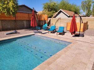 einen Pool mit Stühlen und Sonnenschirmen neben in der Unterkunft Mesa Oasis Private Pool Spacious! 10+ guests 7 Beds New, Great Location! in Mesa