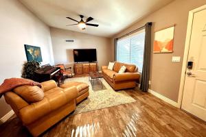 ein Wohnzimmer mit einem Sofa und einem TV in der Unterkunft Mesa Oasis Private Pool Spacious! 10+ guests 7 Beds New, Great Location! in Mesa