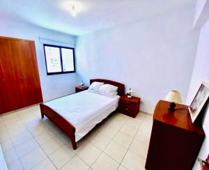 a bedroom with a bed and a dresser and a desk at Mackenzie apartment 301 in Larnaca
