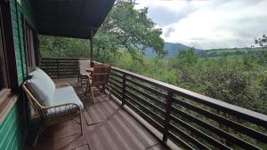 a porch with two chairs and a table on it at Autarke, idyll. Hütte mit Kamin+Aussicht in Dausenau