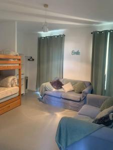 een woonkamer met 2 bedden en een bank bij T3 vue mer in Le Lavandou