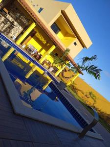 Casa de Praia Pontal في ايليوس: منزل اصفر مع انعكاس في الماء