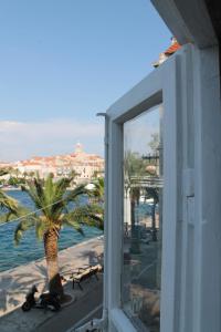a view of a palm tree from a window at Apartment Antares in Korčula +8 photos