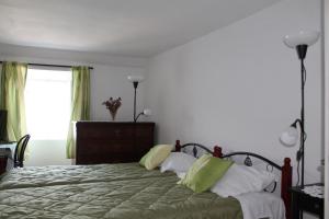 sypialnia z łóżkiem z zielonymi i białymi poduszkami w obiekcie Apartment Antares w Korčuli