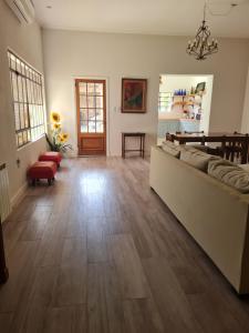 a living room with a couch and a wooden floor at Lechuza del Campanario in San Antonio de Areco