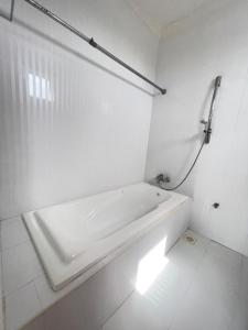 a white bathroom with a tub and a shower at Panda holiday 中国酒店 中国餐厅 VX Gsundindi in Rasdu