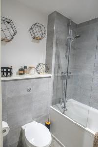 uma casa de banho com um chuveiro, um WC e uma banheira em Modern and Spacious Apartment in Salford Quays em Manchester
