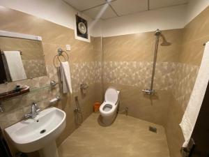 y baño con aseo blanco y lavamanos. en Maria Hotel and Resorts, en Kalām