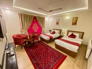 um quarto de hotel com duas camas e um tapete vermelho em Maria Hotel and Resorts em Kalām