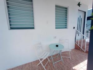 a table and chairs in front of a white wall at Urban Lodgings One @ Roosevelt 457 in San Juan