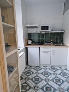 a small kitchen with white cabinets and a tile floor at Seaside in Gdańsk