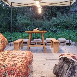 a picnic table and benches under an umbrella at Hooni_guesthouse in Odzun