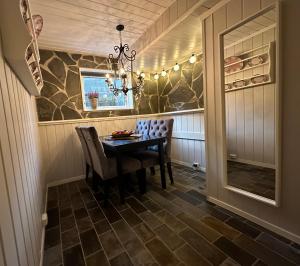 une salle à manger avec une table, des chaises et un lustre dans l'établissement Koselig leilighet i rolig boligfelt, à Gol