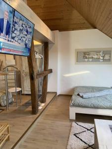 um pequeno quarto com uma cama e uma televisão em Ferienwohnung im Heuboden em Züsch