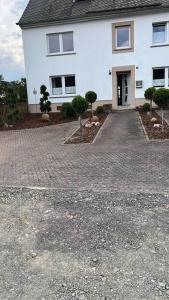 a white house with a driveway in front of it at Ferienwohnung im Heuboden in Züsch